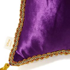 a purple pillow with gold trimmings and a tassel on the bottom side