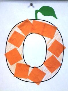 the letter o is made out of construction paper and strips of orange tape with a green leaf on top