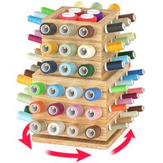 a wooden peg board filled with lots of spools of thread next to an arrow