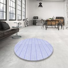 a living room filled with furniture and a purple round rug on the floor in front of a window