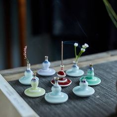 there are many different colored glass items on the table together, including one with a flower in it