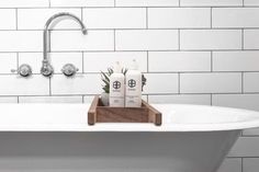 a white bath tub sitting next to a wooden tray