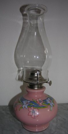 an old fashioned pink glass oil lamp on a table