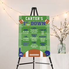 a football themed poster is displayed in front of a white table with flowers and lights