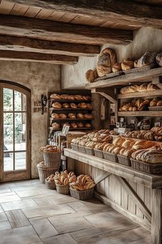 breads and pastries are on display in a rustic bakery shop with stone flooring