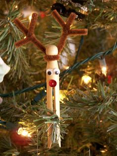 a christmas ornament is hanging from a tree with lights on it and a reindeer head