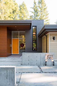 a modern home with concrete steps leading up to the front door and entryway area