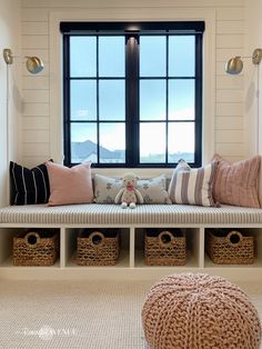 a window seat with pillows and baskets in front of it