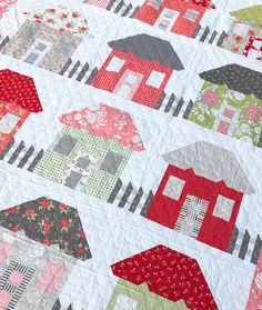 a quilt made to look like houses with red and green roofs on each one side