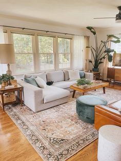 a living room filled with furniture and a large rug on top of a hard wood floor