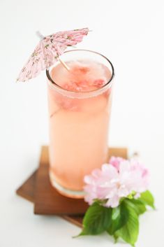 a pink drink with an umbrella garnish on the top