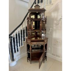 an ornate wooden cabinet in the corner of a room next to a bannister