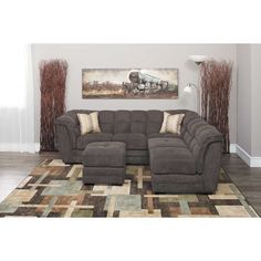 a large sectional couch in a living room with a painting on the wall behind it