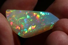 someone is holding an opal in their hand