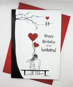 a couple sitting on a bench with two hearts attached to the back of each card