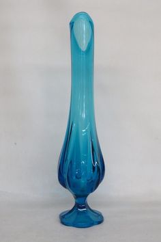 a blue glass vase sitting on top of a table