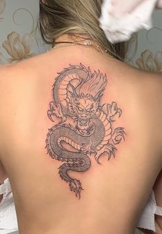 a woman with a dragon tattoo on her back