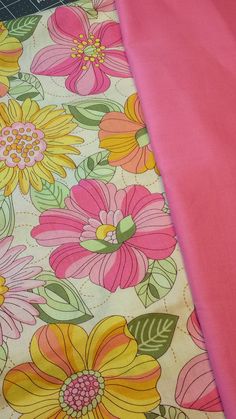 the fabric is pink and yellow with flowers on it