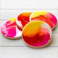 three plates with different colored paint on them