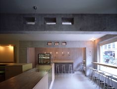 the interior of a restaurant with bar stools and barstools in front of large windows