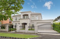 a large white house with an iron gate