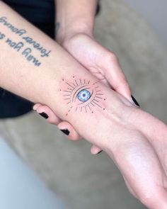 two hands holding each other with an eye tattoo on their arm and the words, never give up may not be as strong as you are