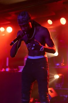 a man standing on top of a stage holding a microphone in front of his face