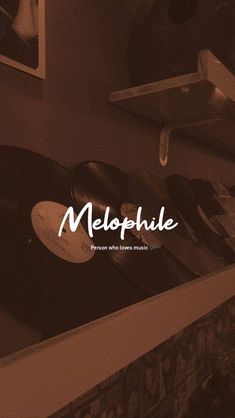 an old record player sitting on top of a shelf next to a wall with the word melopuie written across it