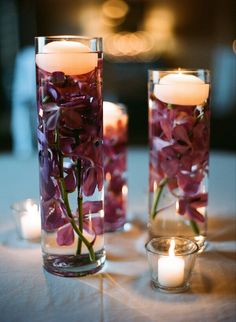 candles and flowers in glass vases on a table