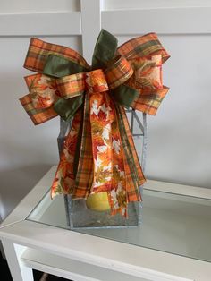 an orange and green bow on top of a glass table