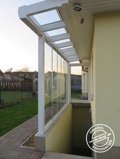 an open window on the side of a house with grass in the backgroud