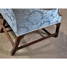 a blue chair sitting on top of a carpeted floor next to a wooden frame