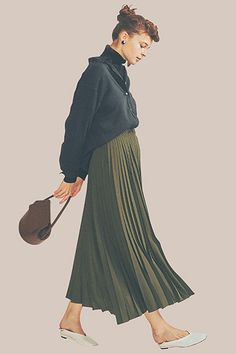 a woman in a green pleated skirt is walking