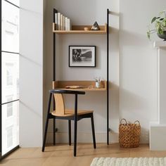 a room with a chair, desk and shelves on the wall next to a window