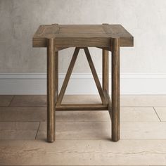 a wooden table sitting on top of a hard wood floor next to a white wall