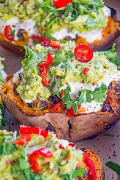 an image of baked sweet potatoes with guacamole and avocado on top