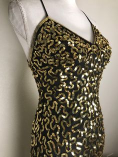 Well nowhello you gorgeous dress! This vintage beauty is from Betsey Johnson's New York Collection and is covered with trailing designs done in gold sequins on a black net background. It is sleeveless with black spaghetti straps which crisscross the back. It is fully lined and has a side zipper. It is in very good preowned condition. It is a size 6 but keep in mind that Betsey's clothes tend to run small so check measurements below. Measurements are taken with garment laying flat.  15 inches und 8th Grade Dance Dresses, Balck Dress, Black And Gold Dress, Gold And Black Dress, Yellow Fits, Black Spaghetti, Vintage Betsey Johnson, Black Spaghetti Strap, Flair Dress