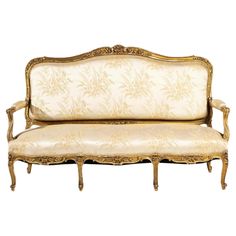 an antique style couch with gold trimmings and white upholstered fabric on the back