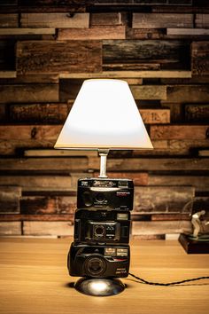 a lamp that is sitting on top of a wooden table in front of a wall