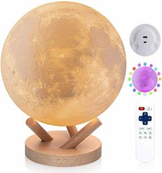 the moon lamp with remote control is shown next to it's wooden base and stand