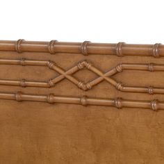 a close up of a wooden bed headboard with bamboo decorations on the top and bottom