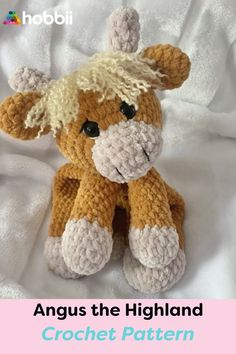 an orange and white crocheted stuffed animal sitting on top of a white sheet