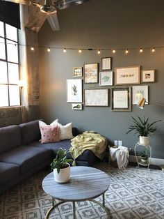 a living room filled with furniture and pictures hanging on the wall above it's coffee table