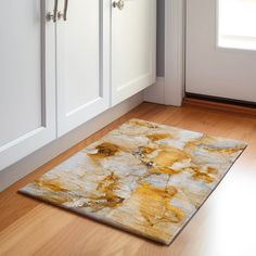 an area rug on the floor in front of white cabinets