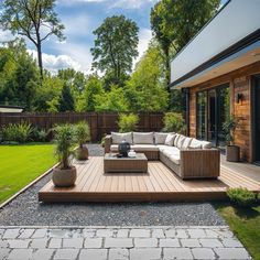 an outdoor living area with couches, tables and potted plants on the deck