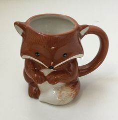 a ceramic mug with a fox design on it