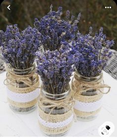 three mason jars filled with lavender flowers on top of a table