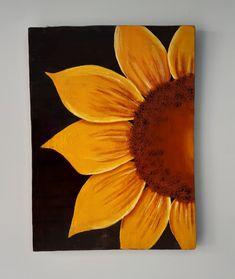 a painting of a sunflower on a black and yellow square with brown center piece