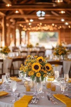 the tables are set with sunflowers and place settings