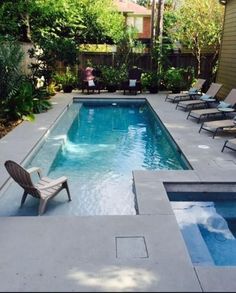 an empty swimming pool with lounge chairs around it